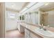 Bathroom featuring a large countertop with dual sinks, a shower, and tile floors at 1011 Dundee Cir, Leesburg, FL 34788
