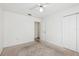 Bedroom featuring carpet flooring, a ceiling fan, and a spacious closet with double doors at 1011 Dundee Cir, Leesburg, FL 34788