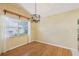 Dining area with laminate wood flooring, modern light fixture and window with white curtains at 1011 Dundee Cir, Leesburg, FL 34788