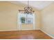 Dining area with laminate wood flooring, modern light fixture, and a window with sheer curtains at 1011 Dundee Cir, Leesburg, FL 34788