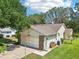 Exterior view showcasing the garage, side yard, and well-kept landscaping at 1011 Dundee Cir, Leesburg, FL 34788