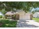 Charming single-story home with stone accents, lush lawn, and mature shade trees at 1011 Dundee Cir, Leesburg, FL 34788