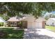 Charming single-story home with stone accents, lush lawn, and mature shade trees at 1011 Dundee Cir, Leesburg, FL 34788