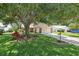 Charming single-story home with mature trees, stone accents and a two car garage at 1011 Dundee Cir, Leesburg, FL 34788