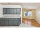 Modern kitchen with gray cabinets, stainless steel appliances, and adjacent dining area at 1011 Dundee Cir, Leesburg, FL 34788