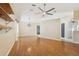 Living room featuring a ceiling fan, wood floors, decorative shelves and natural light at 1011 Dundee Cir, Leesburg, FL 34788