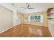 Bright living room with high ceilings, a ceiling fan, hardwood floors, large window and decorative shelves at 1011 Dundee Cir, Leesburg, FL 34788