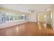 Spacious living room featuring hardwood floors, a ceiling fan, and bright lighting at 1011 Dundee Cir, Leesburg, FL 34788