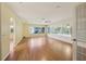 Spacious living room featuring laminate wood flooring, fan, and a sunroom with lots of windows at 1011 Dundee Cir, Leesburg, FL 34788