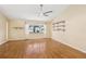 Bright living room with high ceilings, a ceiling fan, hardwood floors, large window, and decorative shelves at 1011 Dundee Cir, Leesburg, FL 34788