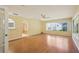 Bright living room with laminate wood flooring, ceiling fan, and lots of natural light from large windows at 1011 Dundee Cir, Leesburg, FL 34788
