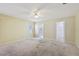 A spacious main bedroom with a ceiling fan and ensuite bathroom at 1011 Dundee Cir, Leesburg, FL 34788