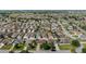 Extensive aerial view of a residential neighborhood with meticulously landscaped yards, near golf course and serene ponds at 1014 Nash Loop, The Villages, FL 32162