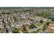 Expansive aerial view of a residential community, showcasing numerous homes and serene ponds under a clear sky at 1014 Nash Loop, The Villages, FL 32162