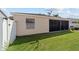 Backyard featuring the screen lanai and a well-maintained lawn at 1014 Nash Loop, The Villages, FL 32162