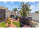 Backyard features a hot tub, patio area with a fire pit and outdoor seating, and lush tropical landscaping at 1014 Nash Loop, The Villages, FL 32162