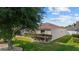 Exterior view of the home, showcasing a well-manicured lawn and mature landscaping at 1014 Nash Loop, The Villages, FL 32162