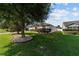 Charming home with a lush green lawn, mature trees, and carefully maintained shrubbery in a serene neighborhood at 1014 Nash Loop, The Villages, FL 32162