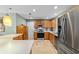 Kitchen boasts stainless appliances, wood cabinets, tile backsplash, and modern fixtures at 1014 Nash Loop, The Villages, FL 32162