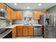 Charming kitchen featuring wooden cabinets, stainless steel appliances, and tile backsplash at 1014 Nash Loop, The Villages, FL 32162