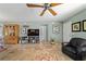 Inviting living room features tile floors, ceiling fan, entertainment center, and a comfortable armchair at 1014 Nash Loop, The Villages, FL 32162