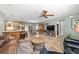 Open-concept living room boasts tile floors, a ceiling fan, and seamless flow to the kitchen at 1014 Nash Loop, The Villages, FL 32162