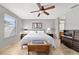 Comfortable main bedroom features natural light, neutral walls, ceiling fan, and tile flooring at 1014 Nash Loop, The Villages, FL 32162