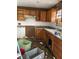 Outdated kitchen with wood cabinets and damaged floor needs renovation at 11626 Fairmont Ave, Leesburg, FL 34788