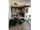 Living room interior showing damage to ceiling, debris on floor and a view of the outdated kitchen at 11626 Fairmont Ave, Leesburg, FL 34788