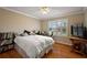 This charming bedroom has a cozy ambiance with beautiful natural light and wood-style flooring at 1175 Johnston Path, The Villages, FL 32162