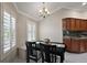 Bright dining area featuring a modern chandelier, plantation shutters, and bench seating at 1175 Johnston Path, The Villages, FL 32162