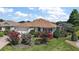 Charming home featuring manicured landscaping, colorful flowerbeds, and a well-maintained lawn at 1175 Johnston Path, The Villages, FL 32162