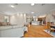 Spacious living room with wood floors flowing into the open kitchen and dining areas at 1175 Johnston Path, The Villages, FL 32162