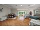 Spacious living room featuring hardwood floors, ample seating, and views of the dining area and backyard at 1175 Johnston Path, The Villages, FL 32162