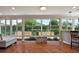 Bright sunroom with large windows, offering views of the lush, landscaped backyard at 1175 Johnston Path, The Villages, FL 32162