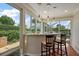 Sunroom featuring a granite countertop bar area, offering views of the pool and backyard at 1175 Johnston Path, The Villages, FL 32162