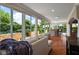 Open sunroom with large windows offering a view of the pool and the lush landscaping at 1175 Johnston Path, The Villages, FL 32162