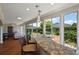 Entertainer's sunroom featuring granite countertops, bar seating, and serene backyard views at 1175 Johnston Path, The Villages, FL 32162