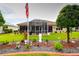 Landscaped backyard featuring a screened-in patio, well-maintained lawn, and decorative landscaping elements at 11868 Se 91St Cir, Summerfield, FL 34491