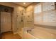 Bright bathroom featuring a glass shower, a soaking tub, and plantation shutters at 11868 Se 91St Cir, Summerfield, FL 34491