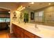 Well-lit bathroom with dual sinks, large mirror, and walk-in shower, providing a luxurious and functional space at 11868 Se 91St Cir, Summerfield, FL 34491
