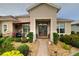 The covered front entrance has a seating area and meticulously maintained landscaping at 11868 Se 91St Cir, Summerfield, FL 34491