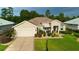 Inviting single-story home features a well-maintained lawn, beautiful landscaping and covered entrance at 11868 Se 91St Cir, Summerfield, FL 34491
