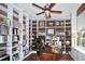 Spacious office featuring custom built-in bookshelves, a dark wooden desk, and a ceiling fan at 11868 Se 91St Cir, Summerfield, FL 34491