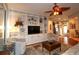 Bright living room with custom built-in shelving, a ceiling fan, and comfortable seating at 11868 Se 91St Cir, Summerfield, FL 34491