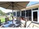 Relaxing screened patio with an umbrella-covered table, ideal for outdoor dining and lounging at 11868 Se 91St Cir, Summerfield, FL 34491