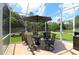 Enclosed patio with table and chairs offers views of the backyard, blending indoor and outdoor living at 11868 Se 91St Cir, Summerfield, FL 34491