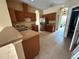 Kitchen with wooden cabinets and stainless steel refrigerator, featuring tile flooring and an archway at 1209 Cathcart Cir, Sanford, FL 32771
