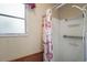 Bathroom with a shower featuring a patterned curtain and a window at 124A Shady Ln, Eustis, FL 32726