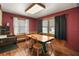 Dining room with red walls, wood floors, and a table with four chairs at 124A Shady Ln, Eustis, FL 32726